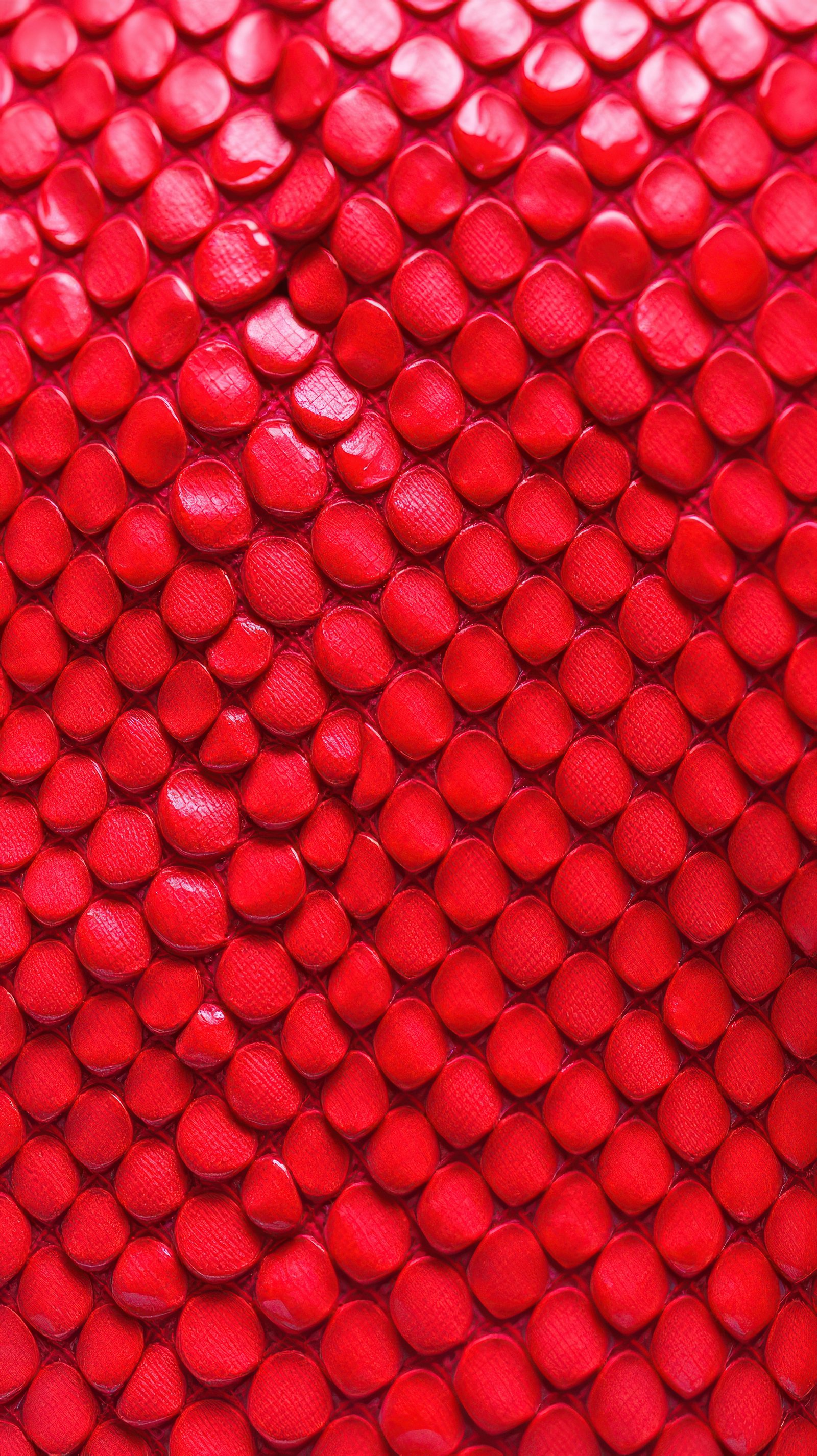 Vibrant red textured surface showcasing unique patterns and shapes from a leather material